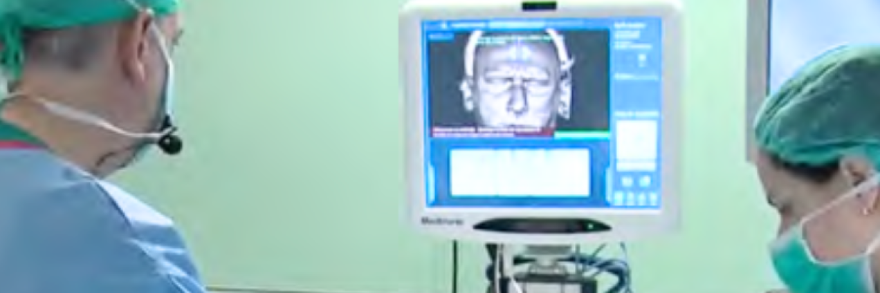 Dos profesionales médicoa mirando una pantalla con una imagen de un cabeza