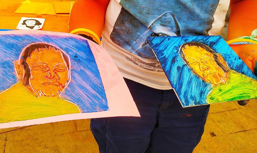 Manos de un joven sujetando dos dibujos