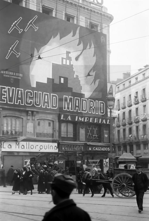Imagen de los edificios de la puerta del sol cubiertos por una lona con la leyenda "evacuad Madrid"