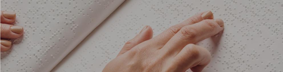 Detalle de una mano durante la lectura de un libro en braille