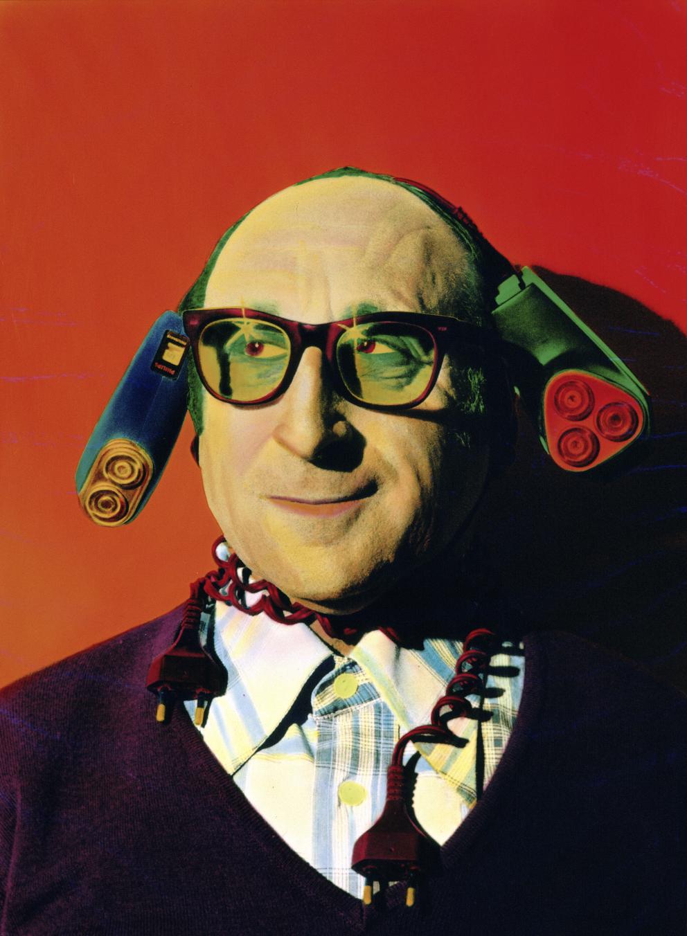 Retrato de un hombre con gafas y dos maquinas eléctricas de afeitar en la cabeza