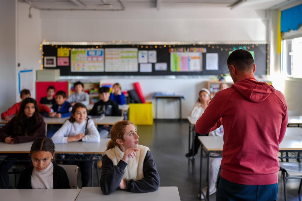 Niños atienden en clase mientras le dan una charla