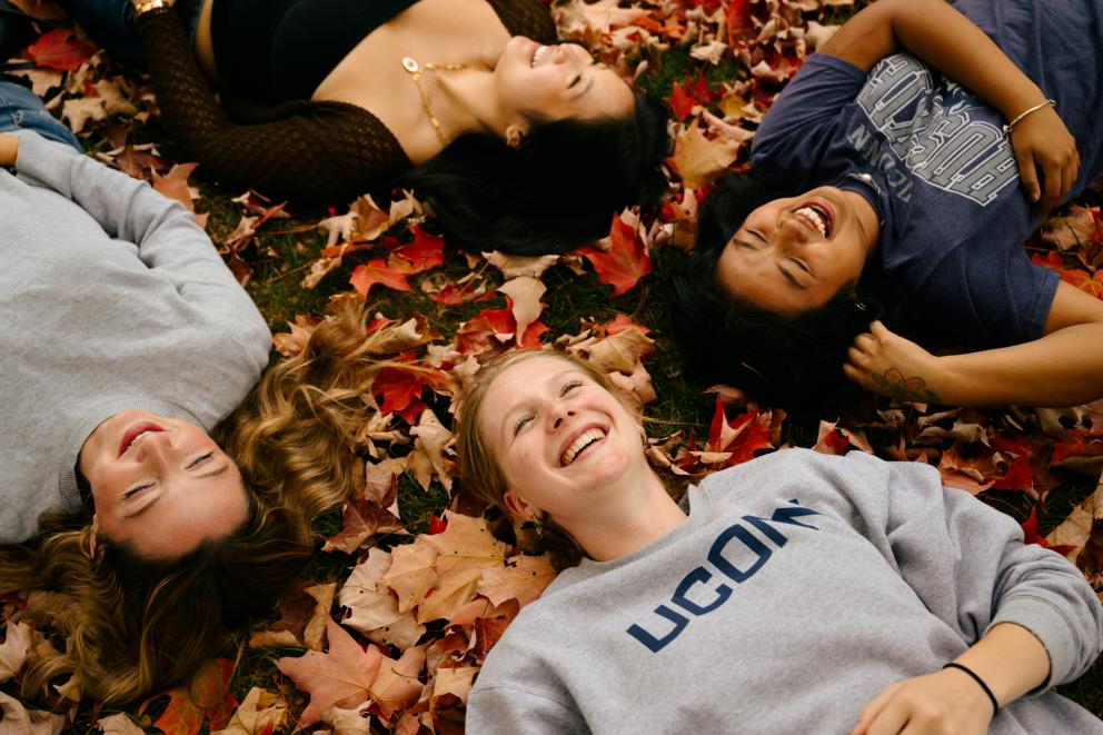 Adolescentes tumbados sobre hojas de otoño