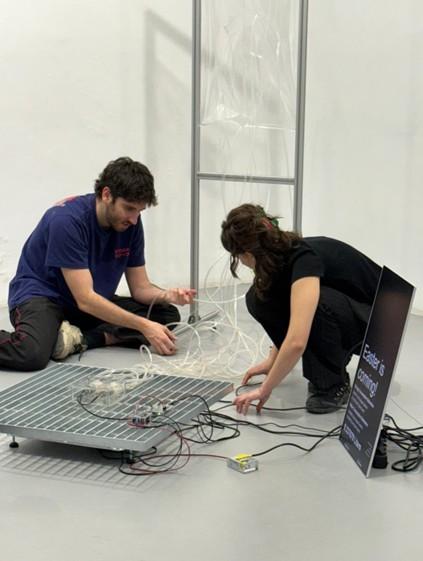 Dos artistas jóvenes trabajando en una instalación artística