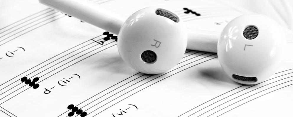 Detalle de unos auriculares sobre una partitura en blanco