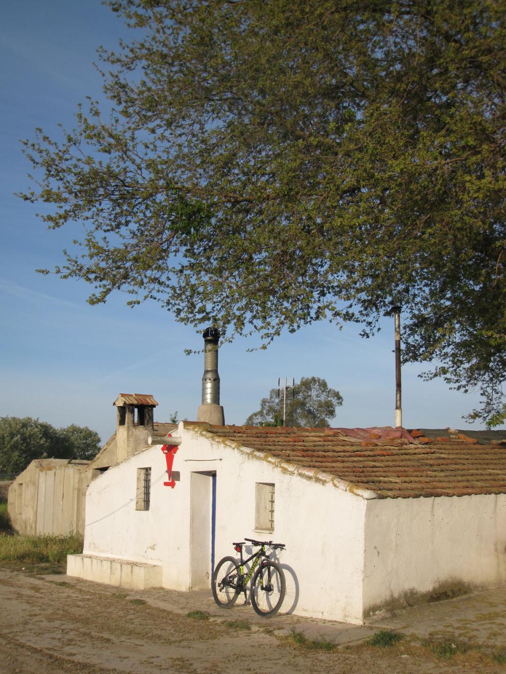 Casita encalada en el camino a Uclés con bicicleta apoyada en su fachada