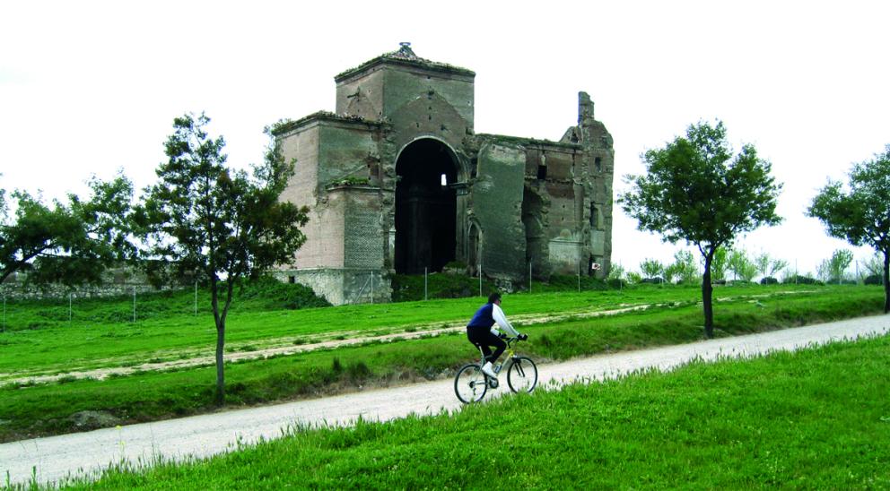 Ciclista pasando por delante de la iglesia de San Pedro, en el Parque Polvoranca