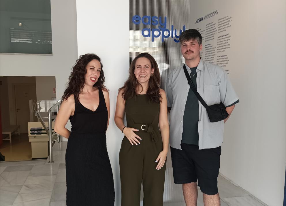 Retrato de dos mujeres y un hombre en una sala de exposiciones de arte contemporáneo