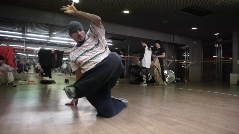 fotografía de un hombre haciendo break dance en un estudio de danza lleno de espejos