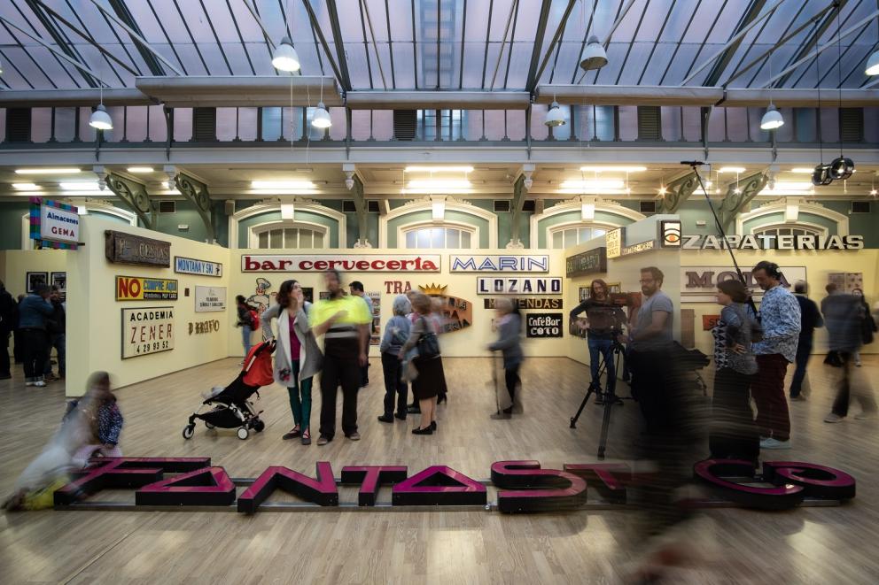 Varias personas visitando una exposición de rótulos