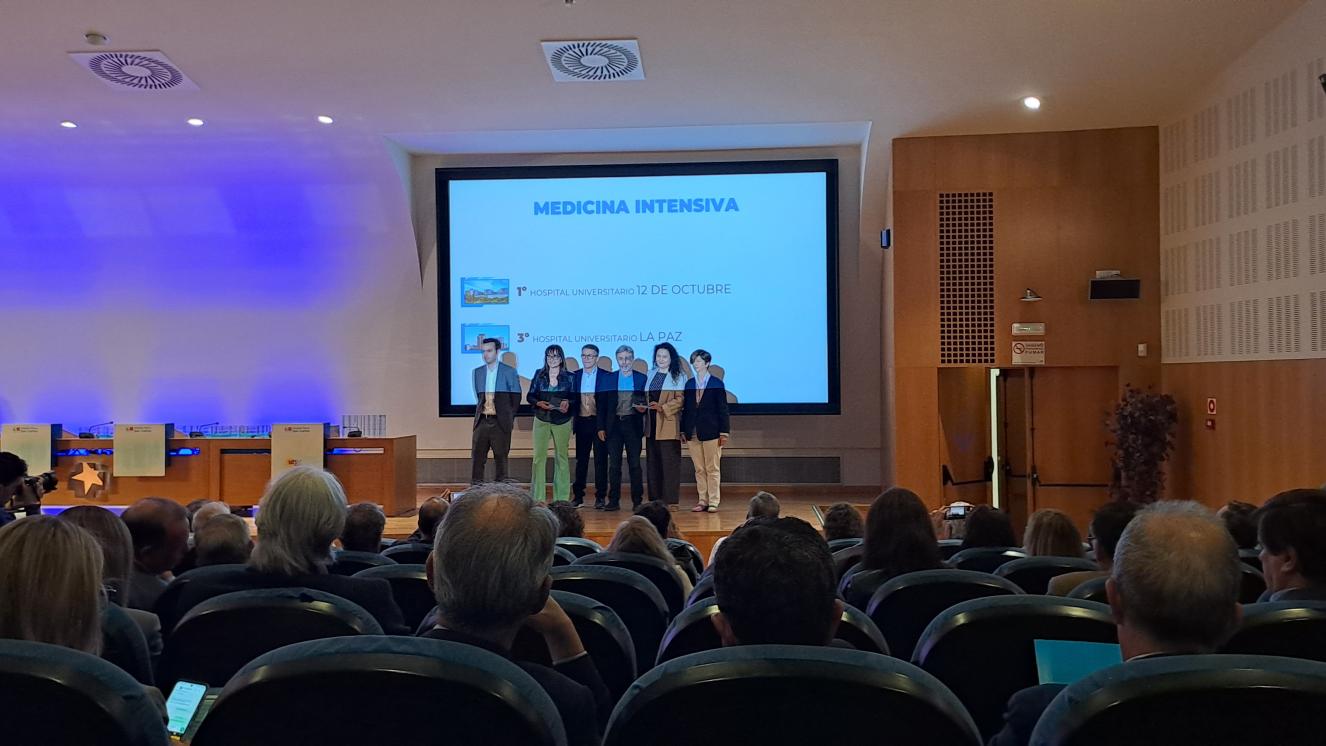 Seis personas en escenario con un premio