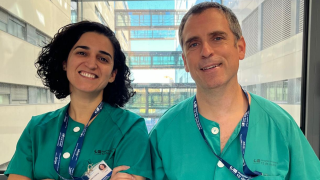 Blanca Gil y Gregorio López con pijama verde de sanitario y delante de estructuras de cristal