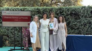 Cuatro mujeres posando en un escenario con un premio que sostiene la segunda por la derecha