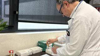 investigador junto a una gradilla de tubos
