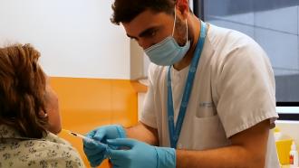 Profesional sanitario administrando bloqueo anestésico a una paciente