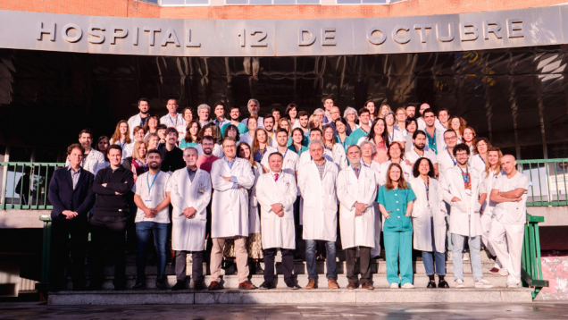 Grupo de profesionales sanitarios con bata posando en escaleras