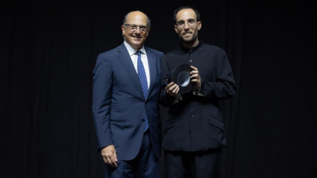 Dos hombres posan uno de ellos con un premio en la mano