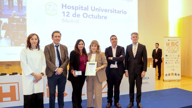 seis personas posando , una mujer a la izquierda y dos en el centro sosteniendo un premio