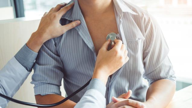 manos de médica auscultando el pecho a un paciente