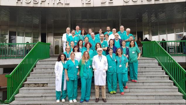 Retrato de grupo de profesionales sanitarios con bata o pijama verde en escalera