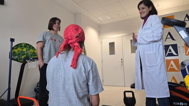 una doctora con bata blanca a la derecha y en el medio un niño de espaldas con un  pañuelo en la cabeza mirando a una mujer que está de frente