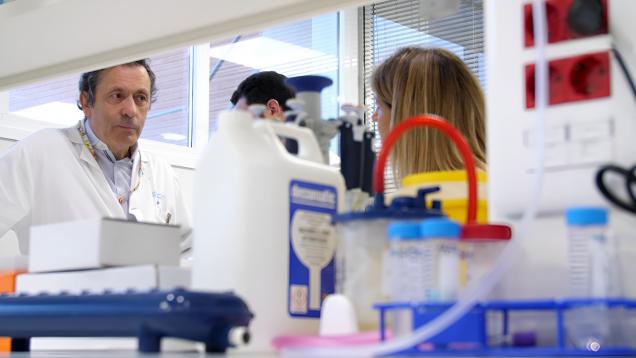 Luis Paz-Ares en su laboratorio al fondo y en un primer plano botes y otros artilugios