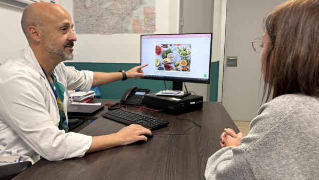 Médico a la derecha en consulta y paciente a la izquiera y `pantalla con alimentos