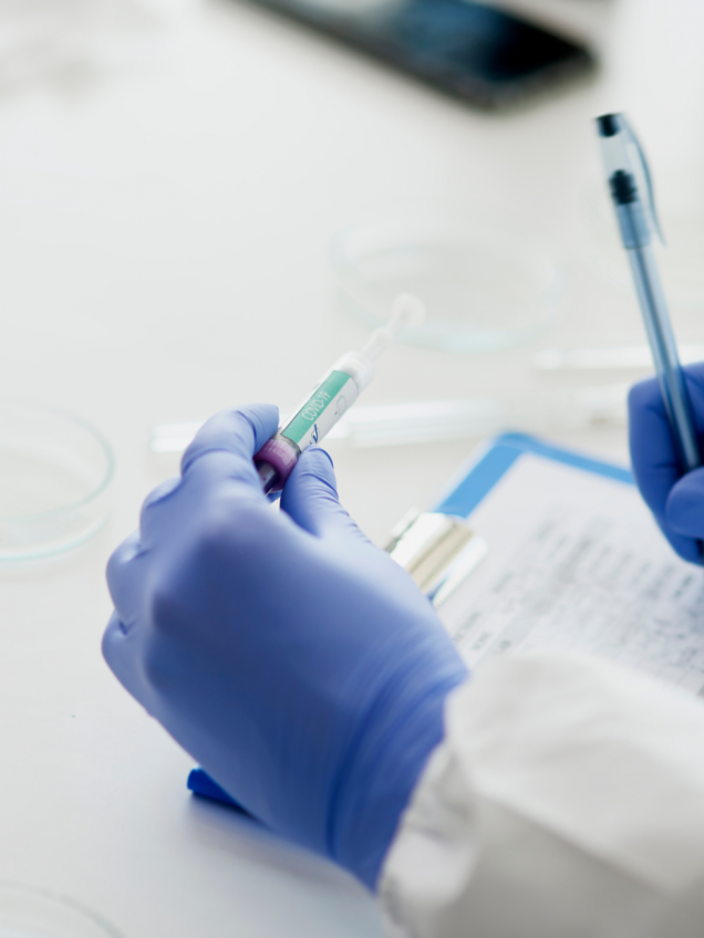 manos con guantes azules escribiendo un formulario