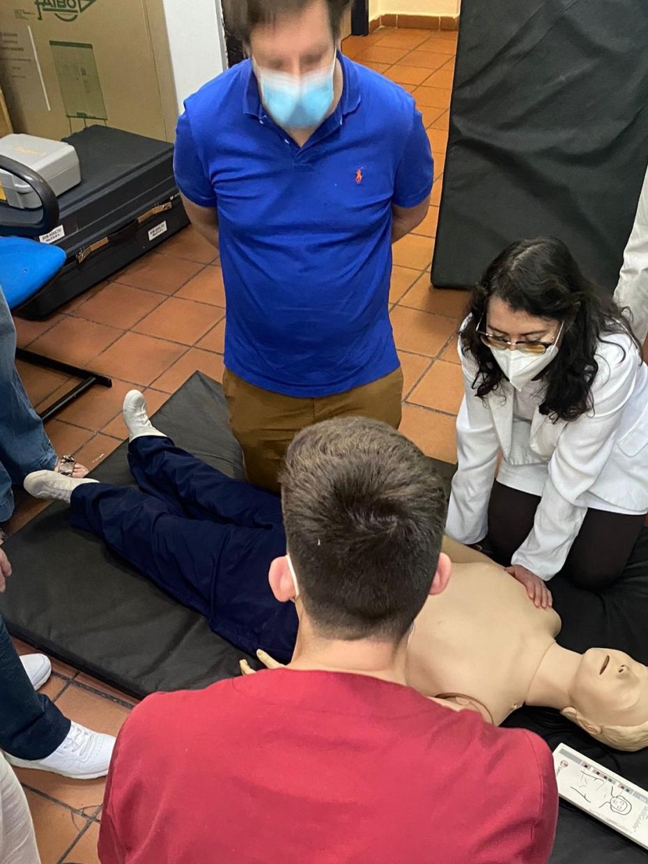Profesionales y adultos haciendo RCP en un muñeco