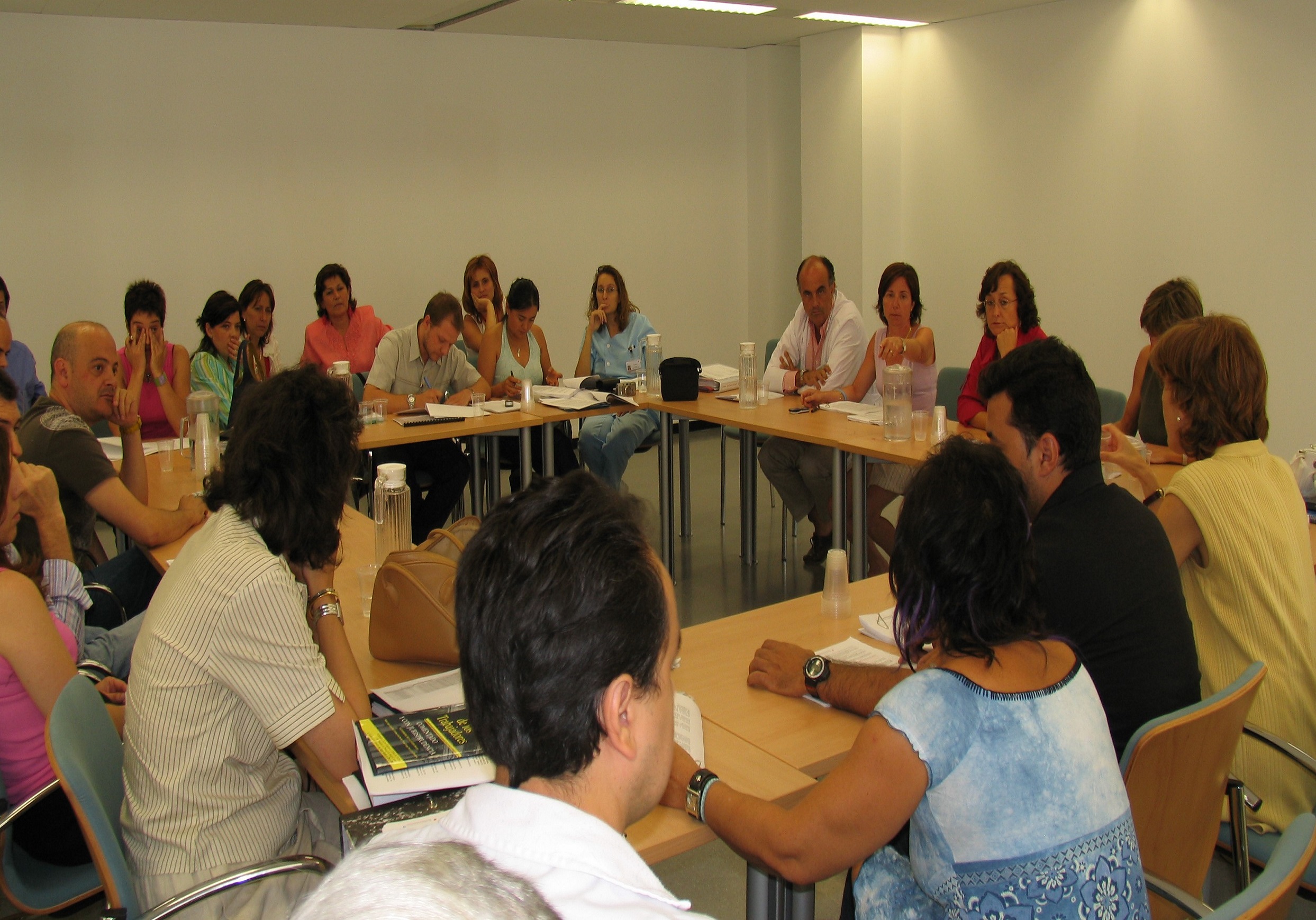 Varias personas alrededor de varias mesas en la firma de documentos