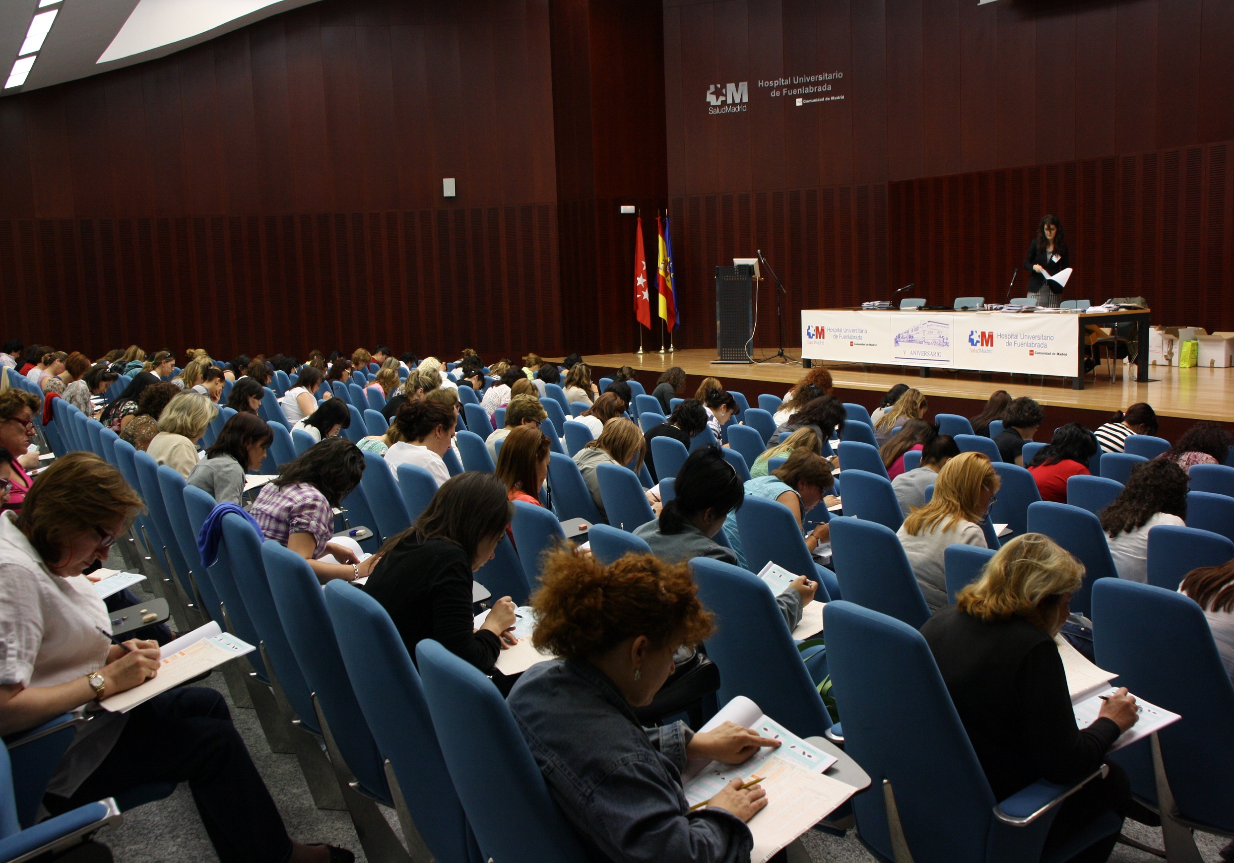 Varias personas haciendo un examen en el salón de actos del hospital 