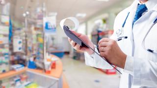 profesional sanitario tomando notas en almacen de medicamentos