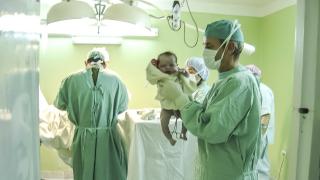 profesionales sanitarios en un paritorio con un bebé recien nacido