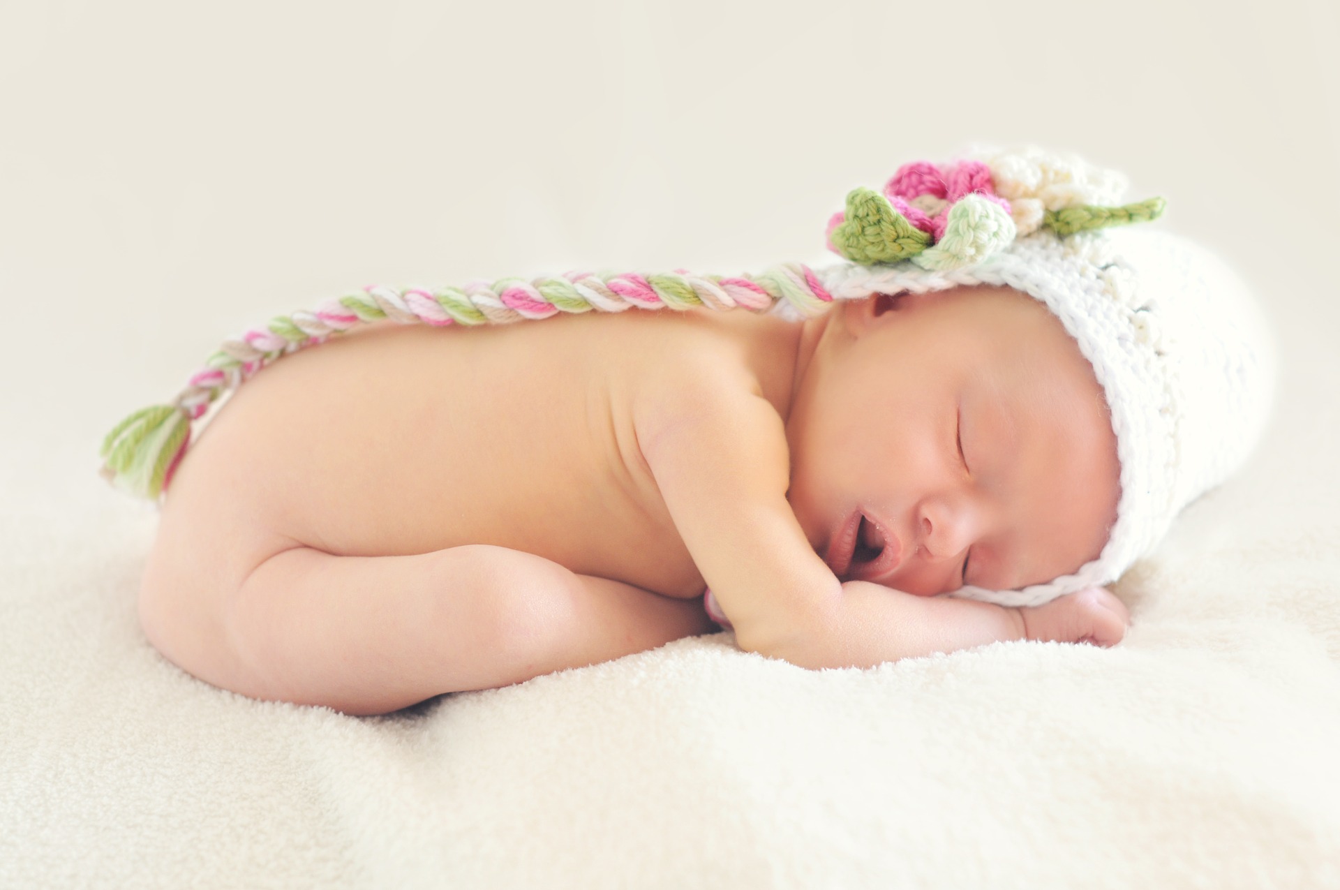 Área pediátrica bebé durmiendo con un gorrito de lana