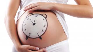 foto de una mujer embarazada con un reloj dibujado sobre la tripa