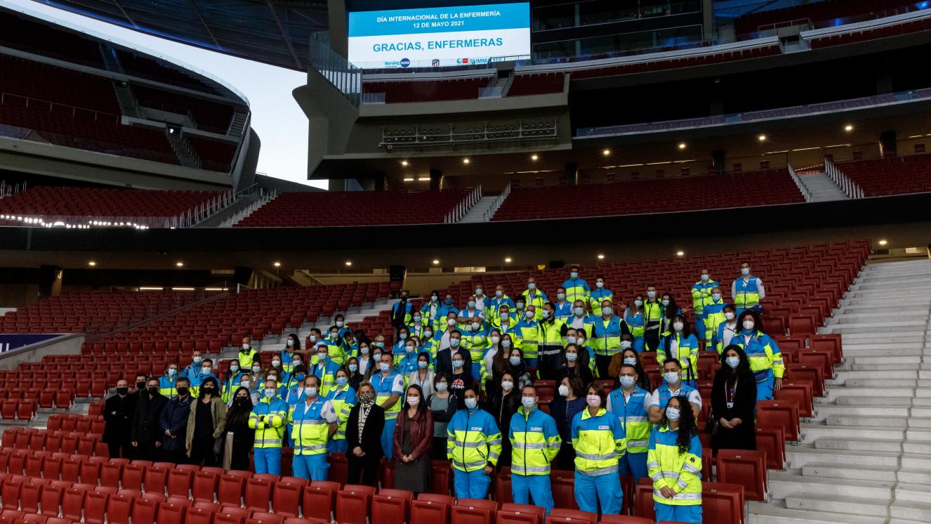 Foto de familia de los profesionales del SUMMA 112 y Hospital Isabel Zendal realizada en la Grada del Wanda Metropolitano, bajo el vídeo marcador con un mensaje de de agradecimiento a las enfermeras. 