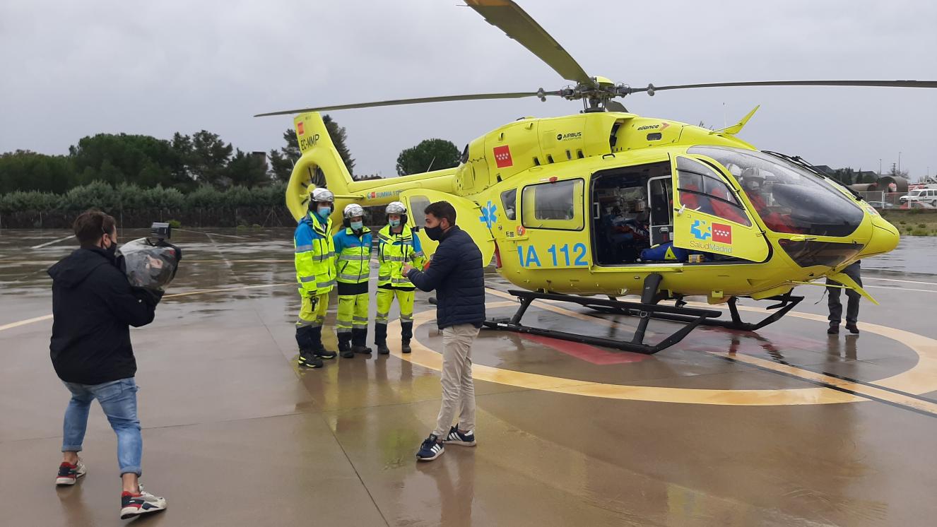Dotación sanitaria del Helicóptero Medicalizado del SUMMA 112 con el Helicóptero de fondo mientras que reportero y cámara de Madrid Directo graban para un reportaje sobre los helicópteros del SUMMA 112