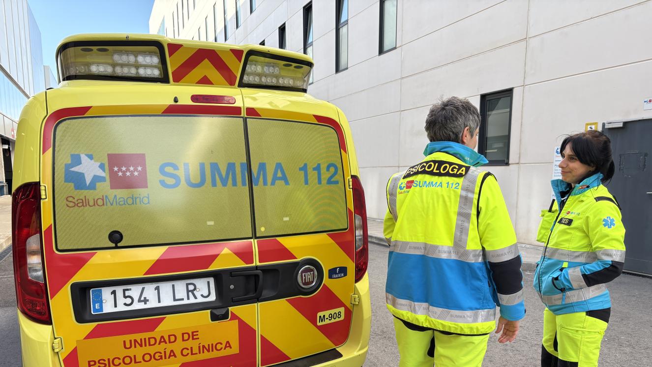 Psicóloga del SUMMA 112 junto a una Técnico de Emergencias Sanitarias del SUMMA 112 uniformadas junto a uno de los vehículos de emergencias del SUMMA 112