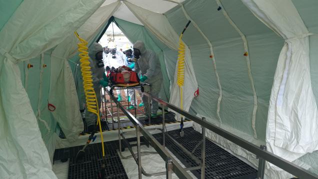 Interior de la línea de descontaminación del SUMMA 112 con el paciente entrando para realizar la desinfección en un simulacro desarrollado en Los Molinos de Madrid