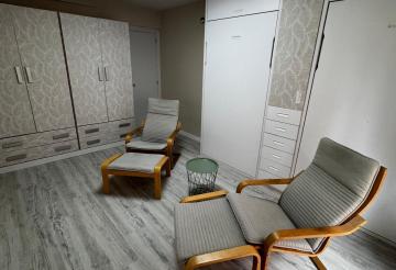 Habitación funcional con camas abatibles por el día recogidas para zona de estudio, relax, etc...