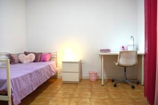 Habitación espaciosa para una persona, luminosa con mobiliario de estudio, de almacenamiento y cama individual.