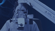Imagen de una persona con indumentaria de centro hospitalario mirando a través de un microscopio