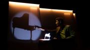 Fotografía del mago tocando el piano en una sombra proyectada sobre una pantalla