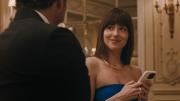 Materialistas Fotograma del largometraje, Dakota Johnson sonría a un hombre que está de espaldas a la pantalla mientras sostiene un teléfono móvil en las manos