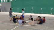 Grupo de jóvenes en círculo en una pista de frontón