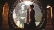 imagen de escena, muestra un hombre en mitad de un escenario que recrea la ciudad de Nueva York y de fondo una fotografía de Lorca proyectada