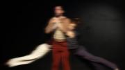fotografía de escena, muestra un hombre, de cada brazo cuelga una mujer oscilando.