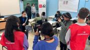 Jóvenes en un aula con cámaras fotográficas enfocando