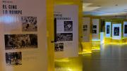Fotografía de la sala de exposición con unos metacrilatos amarillos con fotografías en blanco y negro
