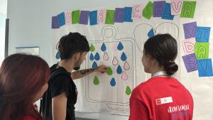 Alumnos y donante colocando gota de sangre en el panel contabilizador